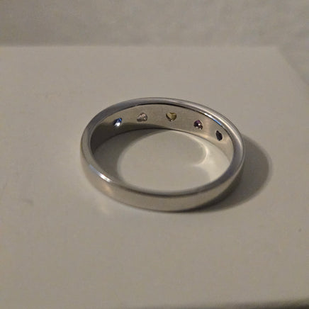 Metallic ring with engraved symbols on a beige background